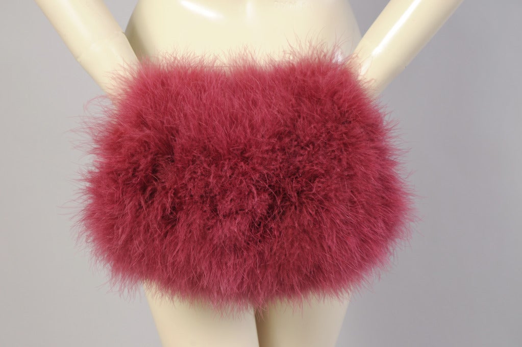 This gorgeous magenta marabou feather muff has a zippered compartment inside, large enough to hold your mobile phone and a few other necessities.  A black velvet strap is attached to one end. As an added bonus it comes with a matching feather hat.