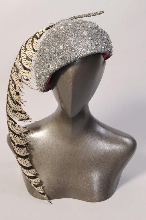 Even the feather is studded with rhinestones on this eye catching silver lame hat designed by Frank Olive. The hat has prong set rhinestones and silver bead decoration. It was retailed by John Wanamaker and it is in excellent