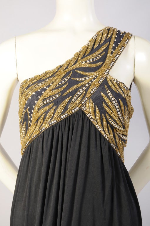 Bob Mackie is best known for glamorous and sexy evening wear and this is an elegant example of his style. Gold bugle beads and rhinestones. in a leaf pattern wrap the bust and continue with a wide strap on the left shoulder. Four narrow beaded