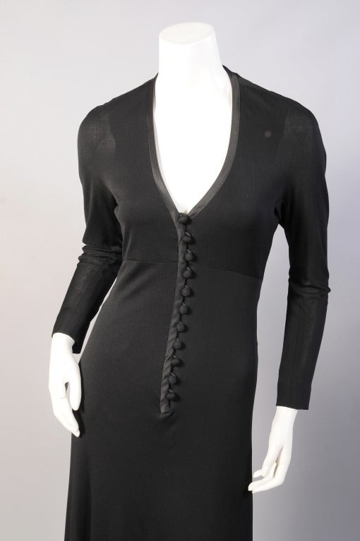 Sexy black jersey is cut low in front while hugging every curve. There is a row of satin buttons and loops matching the trim at the neckline. The dress is fully lined and in excellent condition.
Measurements;
Shoulders 15