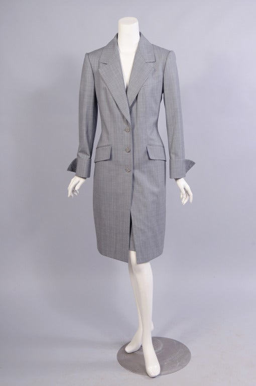 Made from a traditional light weight menswear wool this coat and skirt or coat and pant ensemble is timeless.  The coat has peaked lapels, a three button closure, a breast pocket and two faux hip pockets, as well as French cuffs. The matching