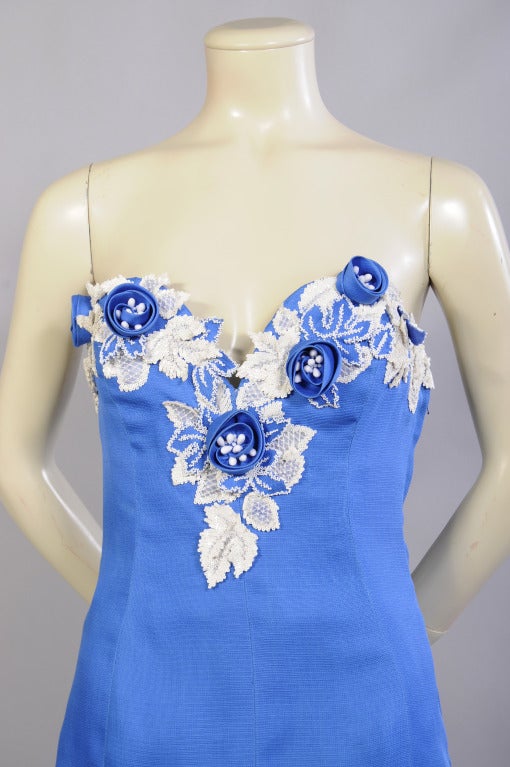 Bright blue silk gazar is hand appliqued with blue and white beaded flowers and leaves on the strapless bodice of this Haute Couture gown from Givenchy.  There is a boned tulle corset inside for support with a left side zipper underneath the left