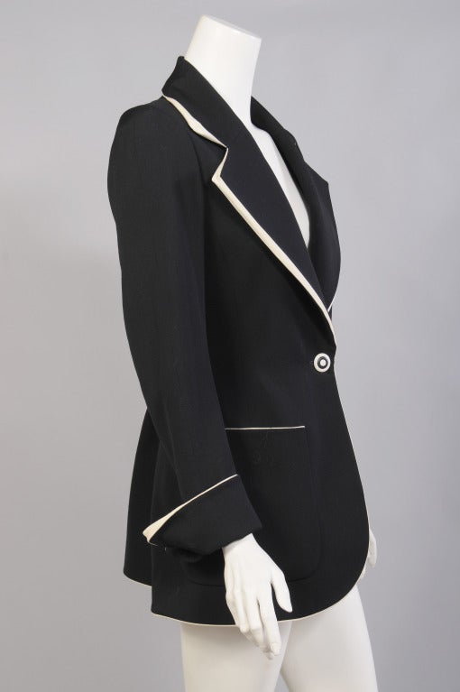 This is a stunning example of the genius that is Karl Lagerfeld. A lightweight black wool one button jacket, is transformed from a basic wardrobe staple to an art piece by the way in which he handles the unusual cream colored piping. The lapels and