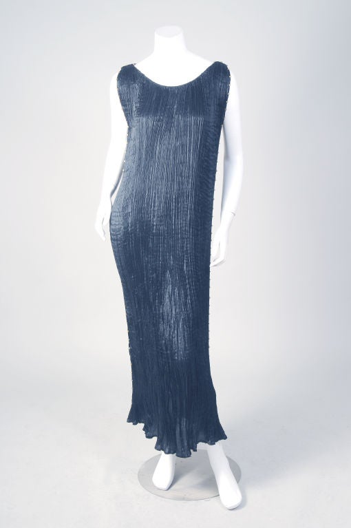 This is a stunning ensemble; a Fortuny black silk Delphos gown and a black silk velvet jacket, stenciled in silver and gold that was designed by Fortuny as well.<br />
The dress is in excellent condition, trimmed on both sides with Venetian glass