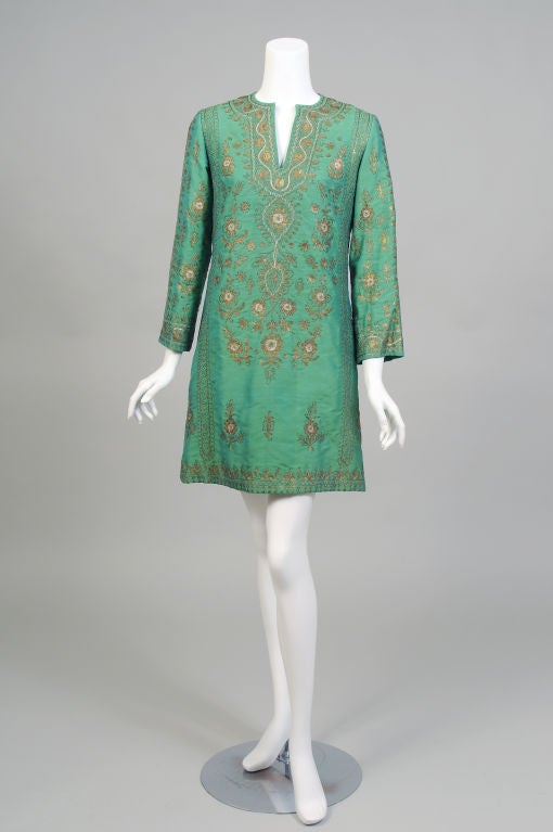 Deep, rich green silk is embellished with silver and gold metallic thread embroidery, all done by hand, in this short caftan.  It is a spectacular choice for so many occasions from casual to dressy.<br />
The caftan is collarless with an open