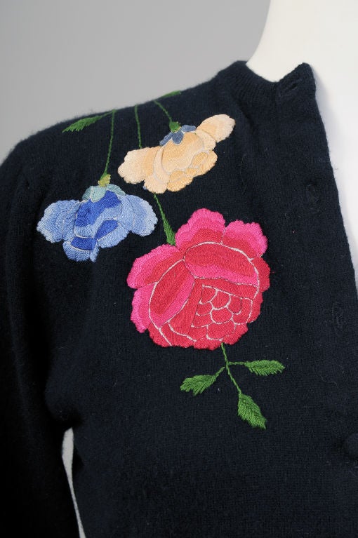 Irene Brown worked in the style of Helen Bond Carruthers.  She took this glamourous cashmere sweater and hemmed it, turned up the cuffs, added black velvet buttons and appliqued colorful Chinese silk hand embroidery.<br />
The floral embroidery was