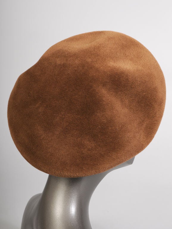 Leave it to Chanel to improve upon the classic French beret. This chic brown hat is made from a substantail wool fabric with a great deal more body than the usual French beret. A wide hat band is lined with a matching grosgrain ribbon and it bears