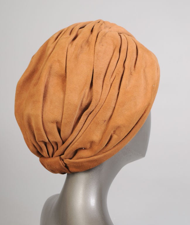 Luscious caramel colored suede is draped from a central point atop the head to create a very glamourous 