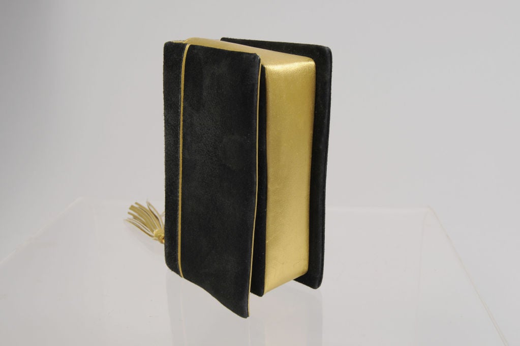 This is such a chic little evening bag designed by Paloma Picasso.  In book form, the bag is black suede with matte gold leather accents, as well as a fringed gold leather 