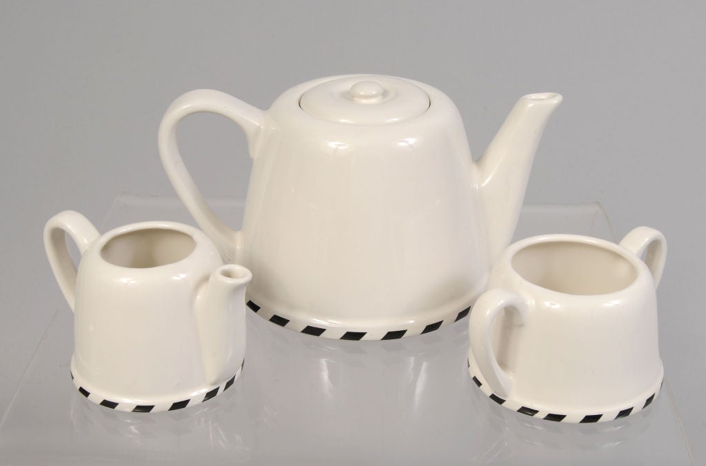 A charming tea set from Geoffrey Beene for Swid Powell, the design firm that specialized in table top items by architects and designers. All three pieces are clad in a removeable bright orange metal cover.  The tea pot cover is lined with a felt