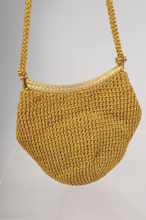 This lovely gold woven metallic bag from the disco era looks so modern forty years later.  The bag has a braided gold double shoulder strap and a rigid gold metal frame.  The body of the bag is woven from gold metallic thread and finished with a
