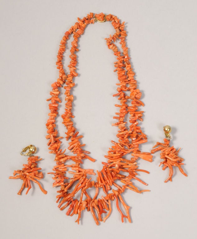 A striking double strand branch coral necklace comes with matching branch coral earrings.<br />
<br />
The necklace is composed of two strands of coral, graduated in size. The clasp is gold washed sterling decorated with branch coral. The clip on