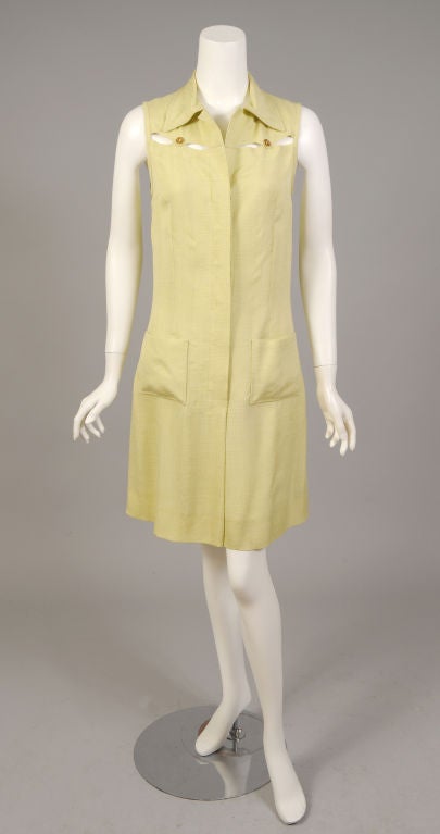 Pale pistachio green silk and gold toned Hermes logo buttons are combined for a very chic and casual summer dress. The dress has an interesting open design at the front and back yokes, anchored by the Hermes buttons. It opens 3/4 of the way down the