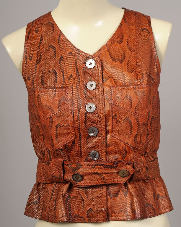 Rust and black python skin make a strong statement in this form fitting vest from Jean Muir. A museum de-accession it is dated 1969 on the museum tags. The skin is soft and supple, and the vest is decorated with a row of grey pearl buttons at the