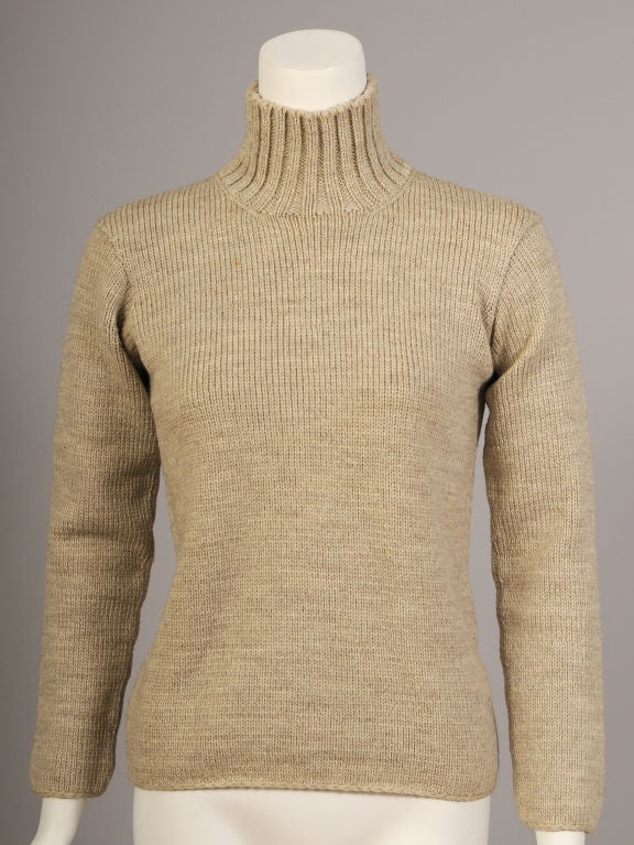 Oatmeal colored wool is hand knit in a traditional slim fit turtleneck sweater circa 1970. The ribbed turtleneck sits above the knit body of the sweater as the only ornamentation.  It is in excellent condition. <br />
<br />
Measurements;<br