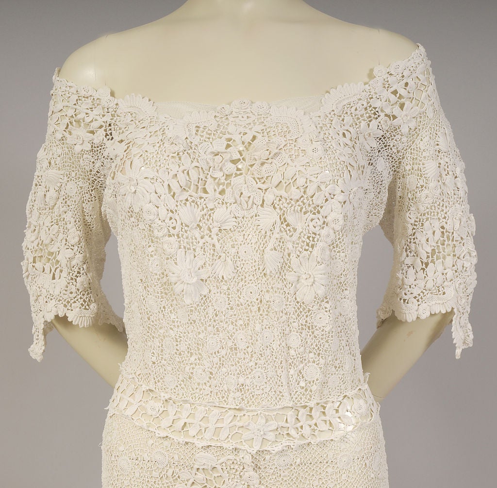 Exquisite hand made Irish lace is used for this feminine and wearable dress from the early 20th century. All of the key design elements are used for this lace, and a floral pattern is used on the bodice, the edge of the sleeves and all around the