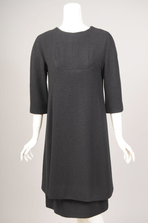 Classic Balenciaga, a black wool two piece dress, is elegant and understated. The design and tailoring are so perfect that all eyes will be on the wearer of this beautiful dress.
The overdress has a scoop neckline perfect for jewels, three quarter