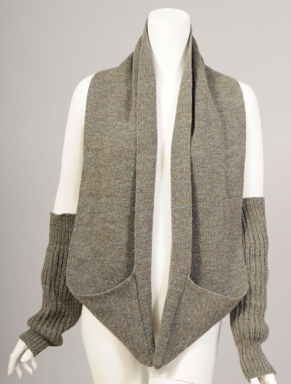 Heathery grey green wool with random flecks of brown is used for this clever scarf and glove set from Joseph Tricot. The long scarf is finished off with triangular pockets at each end. This is just perfect for your hands since the gloves are