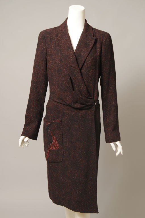 Black wool flecked with red, drapes beautifully in this coat or coat/dress from Christian Lacroix. Traditional notched lapels are draped to the left side, and close with a rhinestone trimmed hook and eye. There is a half belt at the wasitline, a