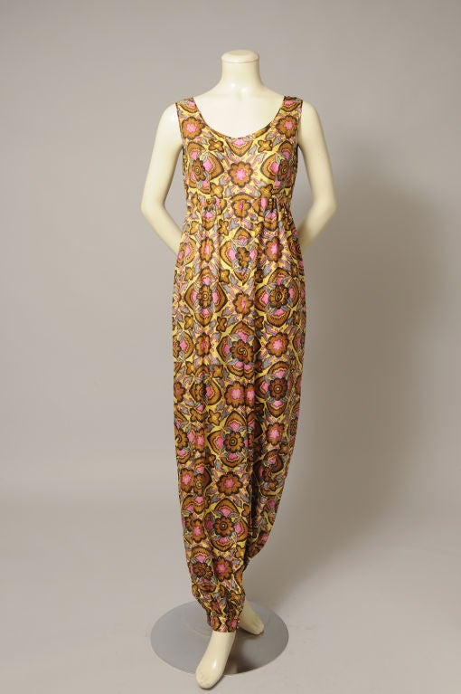 This fabulous piece is from Christian Dior, Paris and it is so unusual!A wonderful silk fabric with a yellow background and a bright Asian inspired print adds to the charm. The jumpsuit or romper has an Empire waistline, a scoop neck, full cut legs