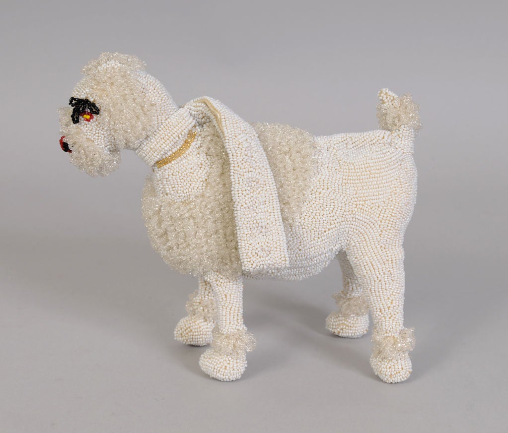 A charming white beaded poodle purse, this was made by Walborg, Belgium in the 1950's. The dog has beaded looped fur, black looped eyebrows, a colorful beaded nose and eyes, and a gold beaded collar. A separate white beaded collar and leash act as a