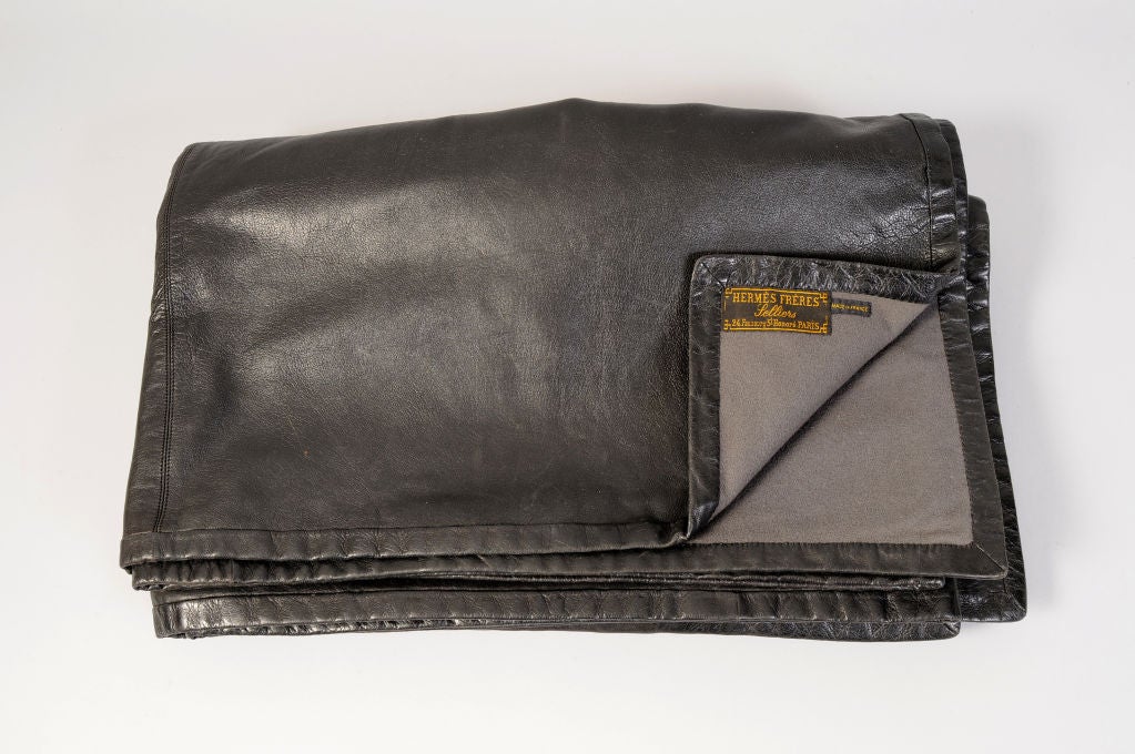 Soft, supple black lambskin is backed with a soft grey wool creating a striking throw from Hermes, Paris. Designed in the early part of the 20th century this blanket bears the label of Hermes Freres in one corner. Anotrher corner is monogrammed CWS