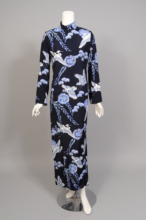 A charming Oriental inspired print in shades of blue and white on a navy background echoes the Chinese inspired styling of this dress. The mandarin collar has a zipper on the left shoulder. The dress is cut slim with deep slits on either side of the