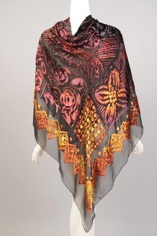 This striking coupe de velours shawl is hand painted on sheer black silk chiffon. The colors shimmer with the light and range from a deep chestnut to a light golden yellow. The shawl is in pristine condition and marked Made in