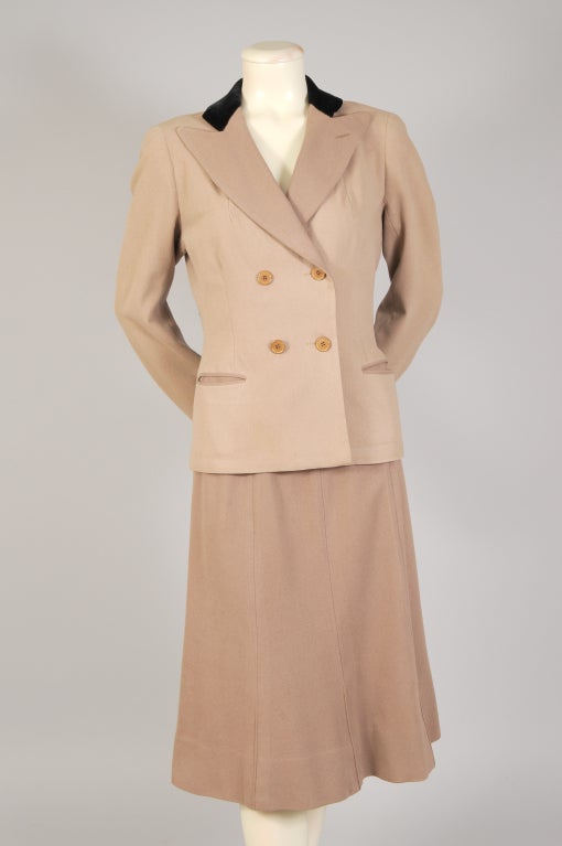 An unusual suit from the Haute Couture house of H. Creed & Co. is created from two slightly different shades of wool. The lapels, collar linings and the skirt are a slightly darker shade than the body of the jacket. The collar and cuffs are deep