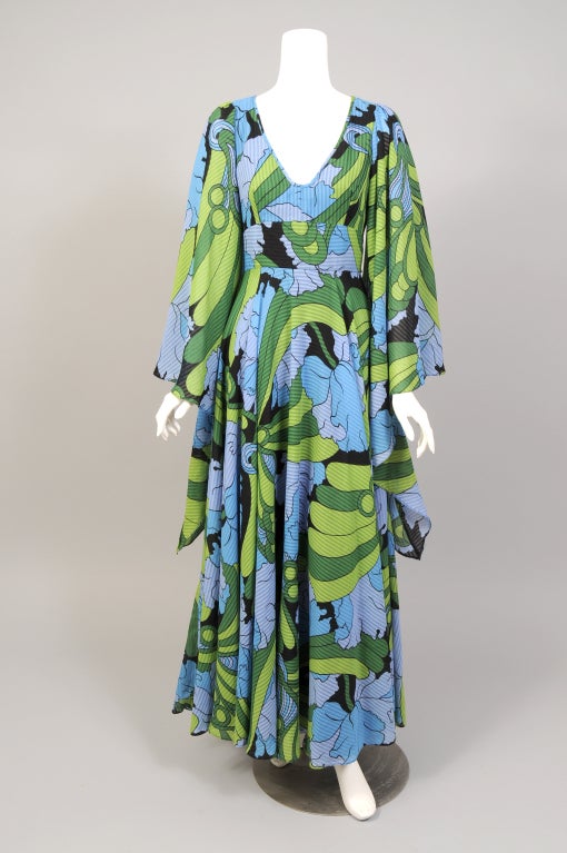 A fabulous printed and woven cotton voile is used for this gorgeous dress designed by Jean Varon and retailed by Harrods.
The dress has a low neckline, Empire waistline, full butterfly sleeves and a long flowing skirt. There is a center back zipper