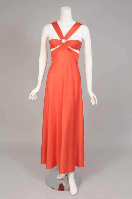 Brilliant orange jersey, is used in this very sexy bandeau top dress from Loris Azzaro.  Two metal rings hold the bodice design in place. The shoulder straps and the bands of fabric covering the breasts snap in place through the ring on the back of