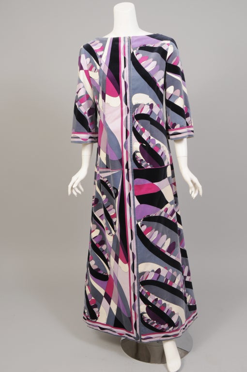 This Emilio Pucci long dress or caftan, has a center front zipper concealed in the exuberant pattern of the velvet. Black and white, slate grey, pale violet, purple and cyclamen are just some of the colors. The piece is styled with an bateau