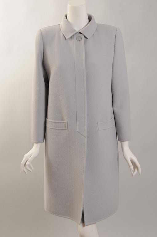 This classic and chic coat from Pierre Balmain was designed by Oscar de la Renta during his tenure as head designer at the House of Balmain. It is made from a very soft grey/blue double faced wool. There is a single button at the neckline and a row