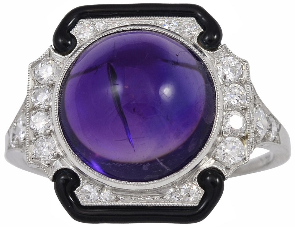A stunning Art Deco Tiffany & Co. cabochon amethyst diamond and enamel ring.  The cabochon amethyst is estimated to be 6.36cts, with approximately .54cts total in diamonds, accented with black enameling, all set in platinum.

Signed  