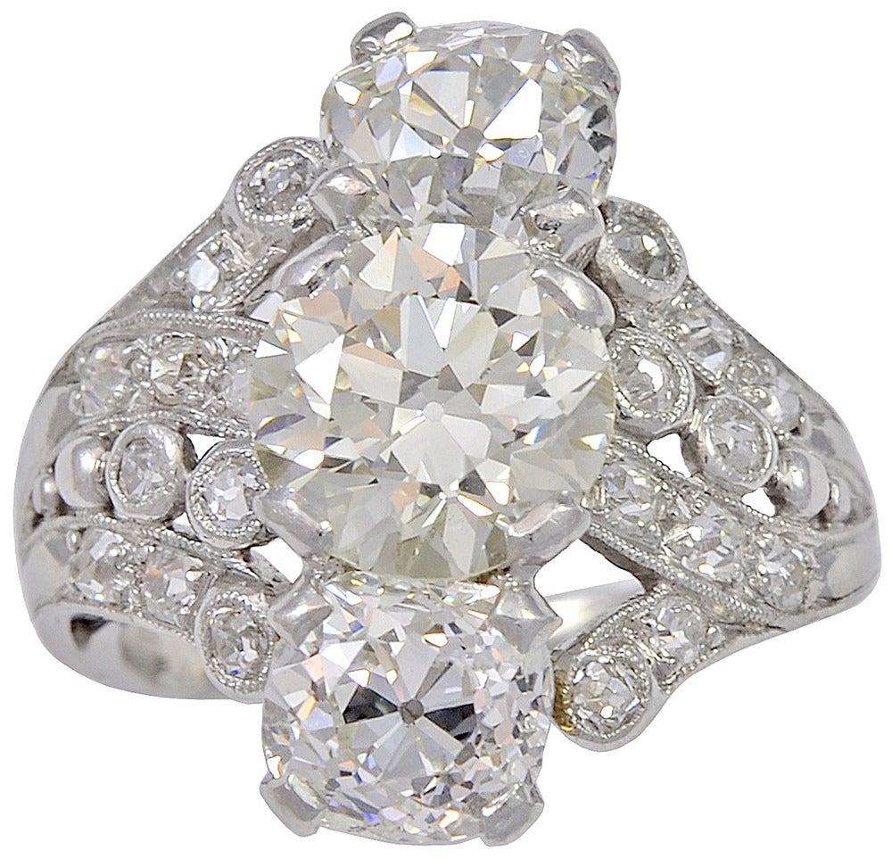 An Art Deco Old European Cut diamond ring.  The center diamond is estimated to b 2.06cts, M color, VS2 clarity.  The two larger side diamond are estimated to be 2.00cts total, with another 0.50cts throughout the rest of the platinum mounting. 