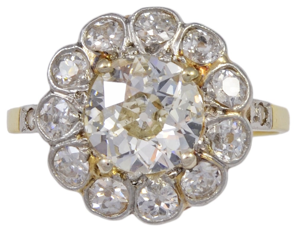 This is a wonderful Victorian Era, old mine cut diamond ring.  The center diamond is estimated to be 1.85cts, J-K color, SI1 clarity.  The center is surrounded by 11 smaller old mine cut diamonds with an estimated total weight of 1.10cts, all set in