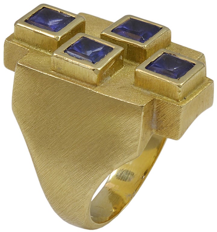 A beautifully designed, Bruno Guidi handcrafted ring. It has four square cut tanzanites, set in an 18k yellow gold, brushed finish mounting. 

Bruno Guidi who devoted his entire career to creating magnificent, one-of-a-kind, hand crafted pieces of