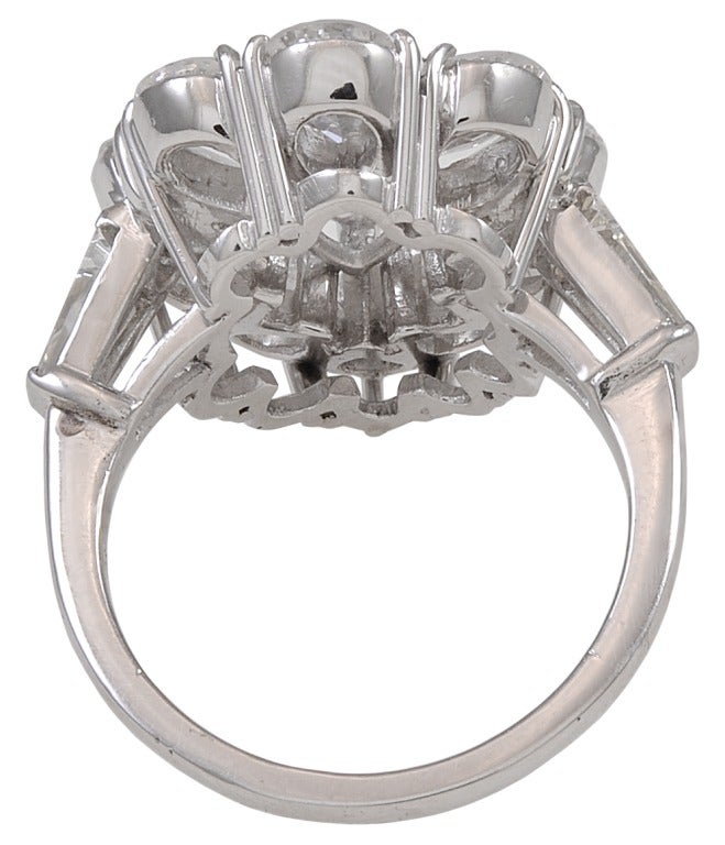 A conversation piece.  This diamond pear shape cluster platinum ring consists of 11 pear shape diamonds and two tapered baguettes.  This is a very unique design.  The center diamond is estimated to be 1.00ct, surrounded by 10 pear shape diamonds