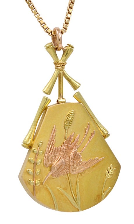 This is a nineteenth century Japanese style pendant created by Tiffany & Co. in 18k rose and yellow gold, with box link chain.  The pendant depicts a crane, heron, or kingfisher amid marsh plants, supported by bamboo rods tied with