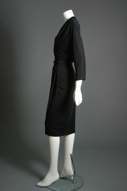 Superb and vampish this wrapping black crepe sheath beautifully cut and draped around the narrow waistband ,Raglan 3/4 sleeves, unlined, France 1950's.

Approx. US size 4, EU 36

DELIVERY INCLUDED IN THE PRICE

Superbe fourreau ''femme fatale
