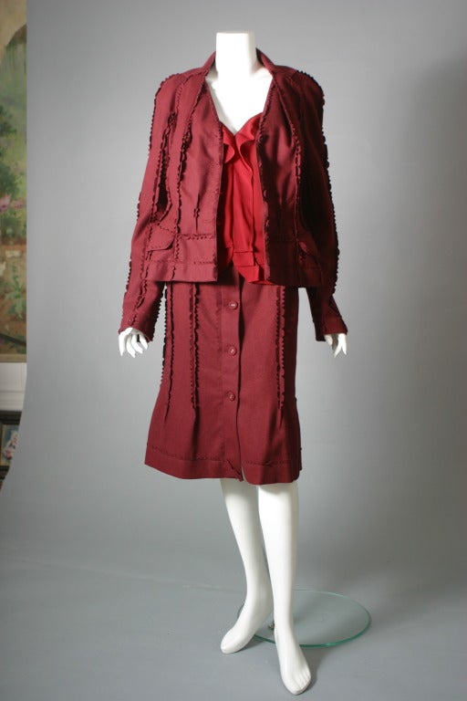 Christian Dior boutique, the three pieces labelled,

Fancy suit composed of a skirt and its jacket of a soft burgundy red, lined with a label '' Dior'' printed red silk lining, adorned with cut work. Matching red silk crepe, sleeveless