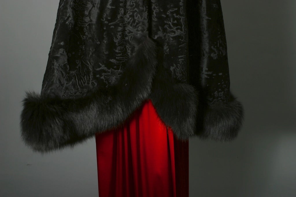 lovely cape in black Breitschwanz  adorned around the collar and the lower hem by a thick fox fur border,asymmetrical curving hem, black polyester lining.
Fur hook at the neck.
To fit a size S to M
FREE DELIVERY INCLUDED IN THE PRICE

Cape en