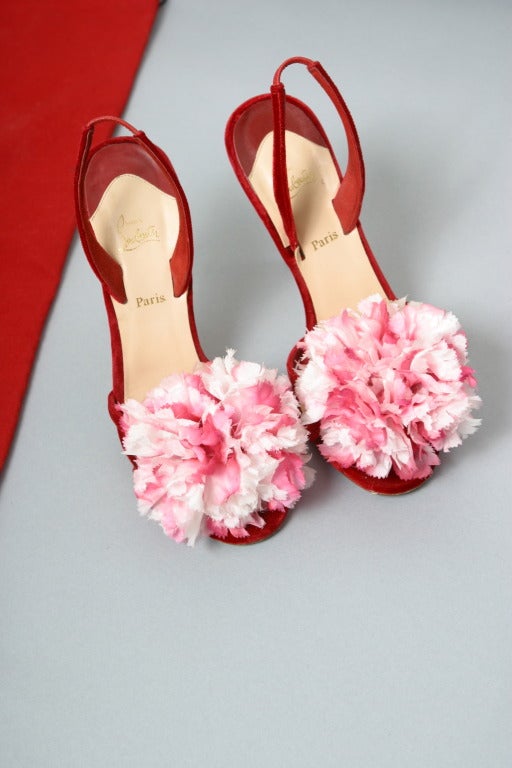 Christian LOUBOUTIN, Paris, circa 2011

Beautiful pair of red velvet evening sandals, adorned with a large shaded pinkish red silk flower on open toe. 
Inner sole of nude leather stamped gold.
Classic red Louboutin soles
Marked size: 37 1/2   