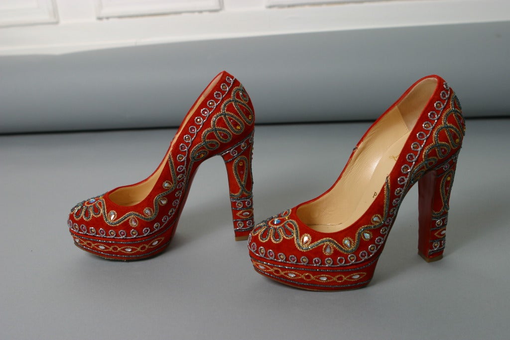 Christian LOUBOUTIN, Paris, circa 2012

Fabulous pair of rust colored suede round toe platform pumps, adorned all over with colored braids and sequins.
Inner sole of nude leather, gold stamp
Classic red LOUBOUTIN soles.

Marked size: 37 1/2  