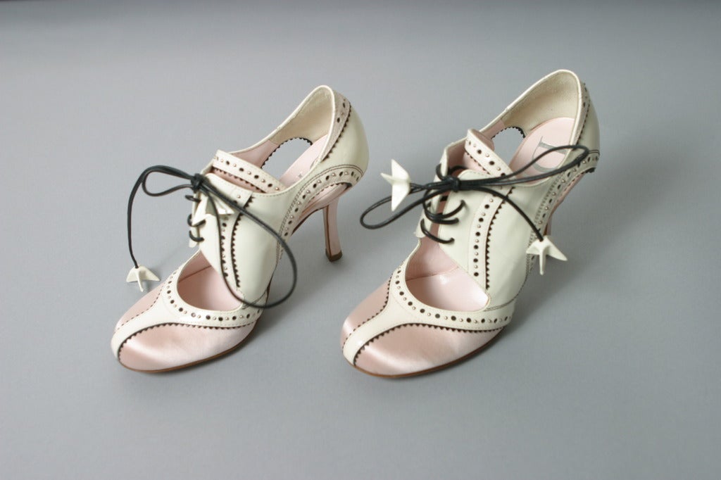 Christian DIOR, By John GALLIANO, Paris, spring- summer 2004

Ultra glamorous exceptional round toe pumps, delicate pink satin, white patent leather edged black, pierced with metallic studs, black ties with decorated tips... 
Inner sole of nude