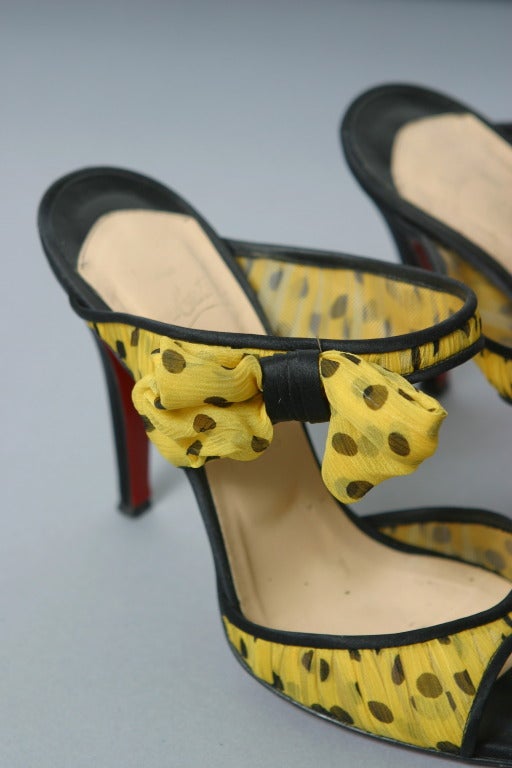 Christian Louboutin , Paris, circa 2012

Amusing yellow and black polka dot chiffon mules, the heel and edges of black satin
Inner sole of nude leather stamped gold.
Classic red Louboutin soles.

Marked size : 37 1/2
Approx. US Size : 7