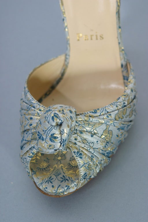 Christian LOUBOUTIN , Paris, circa 2012

Superb draped brocade evening sandals in hues of grey, blue and gold, knotted on toes.
Inner sole of nude leather stamped gold.
Classic red LOUBOUTIN soles
Made in Italy

Marked size : 37 - US size