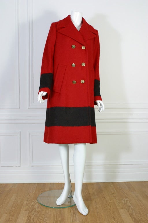 GUCCI

Red woolen coat, V neck, double line of three stamped '' GUCCI'' gilt buttons, Two hidden side pockets, lower part of the coat and sleeves have a large black band.
Stamped '' GUCCI '' on a gilt metal chain on the inside collar.
Size EU