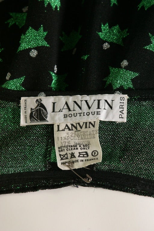 LANVIN boutique, cira 1970

A Lanvin boutique black and emerald green stars, lurex jersey, long evening dress. Labelled ''LANVIN boutique '', plunging V neckline finishing by a cross over back fastening with bow to the front, partly covering a