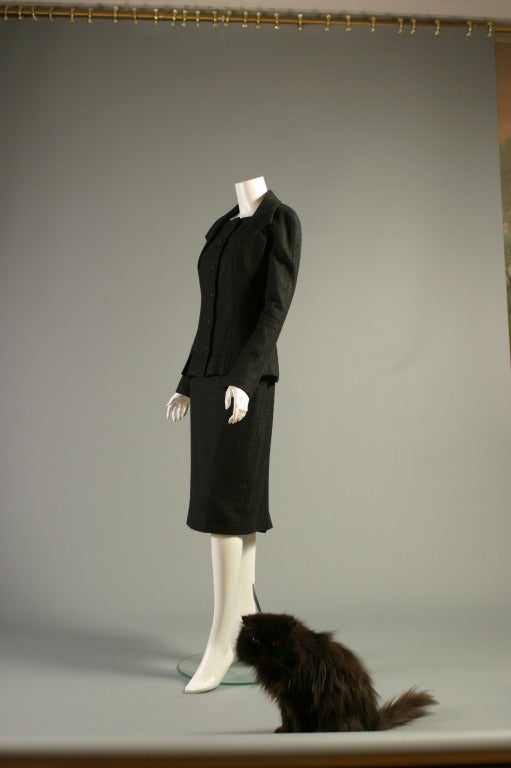 Christian DIOR, by John GALLIANO, circa 2004- 2005

A very elegant black and grey hound's tooth checked cashmere suit, un- labelled.
The ''bar suit '' inspired jacket, with a square neckline, bolero shaped seams to the buttoned front